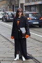 MILAN, ITALY - FEBRUARY 24, 2023: Woman with black jacket and orange shirt before Sportmax fashion show, Milan Fashion Week street