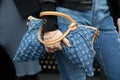 MILAN, ITALY - FEBRUARY 24, 2023: Woman with blue denim Louis Vuitton bag before Gucci fashion show, Milan Fashion Week street