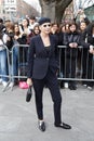 MILAN, ITALY - FEBRUARY 23, 2023: Woman with blue jacket, trousers, and cap before Emporio Armani fashion show, Milan Fashion Week