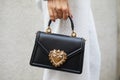 MILAN, ITALY - FEBRUARY 23, 2023: Woman with Dolce and Gabbana bag with golden heart before Genny fashion show, Milan Fashion Week