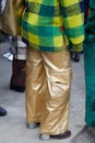 MILAN, ITALY - FEBRUARY 22, 2023: Woman with golden cargo trousers and yellow and green checkered jacket before Fendi fashion show