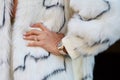 Woman with golden Rolex Daytona, ring with gem and white fur coat before Fendi fashion show,