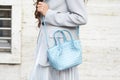 MILAN, ITALY - FEBRUARY 25, 2023: Woman with light blue leather bag, grey jacket and silver skirt before Missoni fashion show,