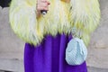 Woman with light blue Loewe bag, yellow fur jacket and purple skirt before Prada fashion show, Royalty Free Stock Photo