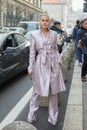 MILAN, ITALY - FEBRUARY 23, 2023: Woman with light pink metallic trench coat and trousers before Genny fashion show, Milan Fashion