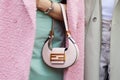 MILAN, ITALY - FEBRUARY 22, 2023: Woman with pale pink Fendi bag with golden logo and turquoise dress before Fendi fashion show,