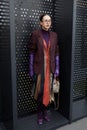 MILAN, ITALY - FEBRUARY 24, 2023: Woman with purple leather gloves and dress made of ties before Gucci fashion show, Milan Fashion