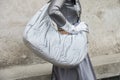 MILAN, ITALY - FEBRUARY 23, 2023: Woman with silver bag and gloves before Prada fashion show, Milan Fashion Week street style