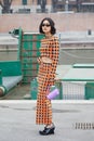 MILAN, ITALY - FEBRUARY 24, 2023: Woman with top and skirt with orange and black polka dot before Sportmax fashion show, Milan