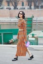 MILAN, ITALY - FEBRUARY 24, 2023: Woman with top and skirt with orange and black polka dot before Sportmax fashion show, Milan