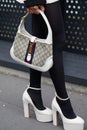 MILAN, ITALY - FEBRUARY 24, 2023: Woman with white Gucci bag and high heel shoes before Gucci fashion show, Milan Fashion Week