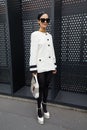MILAN, ITALY - FEBRUARY 24, 2023: Woman with white jacket and shoes before Gucci fashion show, Milan Fashion Week street style