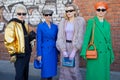 Women with golden, blue, purple, green clothing before Fendi fashion show, Milan Fashion Week
