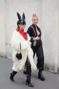 MILAN, ITALY - FEBRUARY 23, 2023: Women with white fur coat, black leather boots and rabbit mask before Prada fashion show, Milan