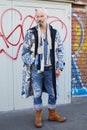 Man with blue denim trousers, white and blue scarf and glasses before Fendi fashion show, Milan