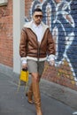 Man with brown and white sheepskin jacket and shorts before Fendi fashion show, Milan Fashion