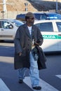 Man with grey coat and overize denim trousers before Gucci fashion show, Milan Fashion Week