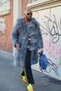 Man with grey fur coat and yellow fluorescent sneakers before Fendi fashion show, Milan Fashion Royalty Free Stock Photo