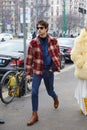 Man with red, beige and black checkered shirt and blue denim shirt before Gucci fashion show