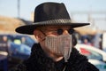 Man with rhinestones face mask, black hat and fur coat before Gucci fashion show, Milan Fashion