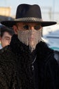 Man with rhinestones face mask, black hat and fur coat before Gucci fashion show, Milan Fashion