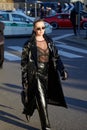 Woman with black leather trench coat and trousers before Gucci fashion show, Milan Fashion Week