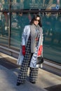 Woman with black and white checkered trousers before Emporio Armani fashion show, Milan Fashion