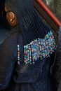 Woman with braids with beads and black Fendi logo pattern jacket before MSGM fashion show, Milan