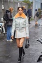 Woman with gray jacket and skirt with orange fur before Magliano fashion show, Milan Fashion Week