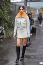 Woman with gray jacket and skirt with orange fur before Magliano fashion show, Milan Fashion Week