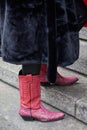 Woman with pink leather cowboy boots and black fur coat before Frankie Morello fashion show,