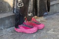 Woman with pink Moncler sneakers and black leather trench coat before MSGM fashion show, Milan