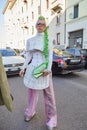 Woman with white dress, green braid and pink trousers before Msgm fashion show, Milan Fashion