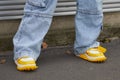 Woman with yellow and white sneakers and blue denim trousers before Prada fashion show, Milan Royalty Free Stock Photo