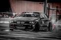 Black BMW racing car in action on wet asphalt Royalty Free Stock Photo