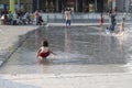 Child splashing at business hub, Milan