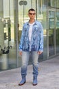 Man with blue denim jacket and trousers and white Diesel shirt before Etro fashion show, Milan