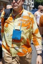 Man with Jacquemus blue leather bag and yellow and orange shirt before Etro fashion show, Milan