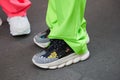 Men with Versace sneakers and green and pink trousers before Versace fashion show, Milan Fashion