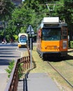 Milan, Italy - June 18, 2017: Milan public rail transport tram arriving at its stop with another vehicle in the background