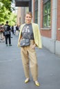 Woman with black Fendi leather bag, beige trousers and yellow checkered jacket
