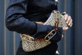 Woman with brown logo pattern Fendi bag and black shirt before Fendi fashion show, Milan