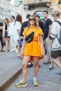 Woman with orange Palm Angels dress and Nike pouch with rainbow strap before Palm Angels fashion