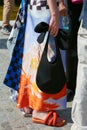 Woman with orange slippers, black bag and colorful skirt before MSGM fashion show, Milan