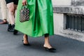 Milan, Italy - June, 19, 2022: woman wears high heels from Prada and land Symbole mini bag.