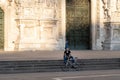 Milan, Italy - May 4, 2020: Bicyclist sitting on Duomo square. Italy enters second phase of coronavirus lockdown.