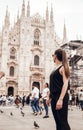 Milan, Italy - May 16, 2018: Brunette girl with ponytail looking at Duomo cathedral in Milan Italy. Milan Cathedral