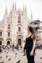 Milan, Italy - May 16, 2018: Brunette girl with ponytail looking at Duomo cathedral in Milan Italy. Milan Cathedral