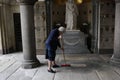 Milan, Italy - May 9, 2014: Older woman cleaning tombs in a cemetery of Milan