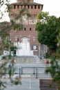 Milan, Italy - May 4, 2020: people walking outdoor, sitting near Sforza Castle fountain wearing face mask. On May 4th Royalty Free Stock Photo